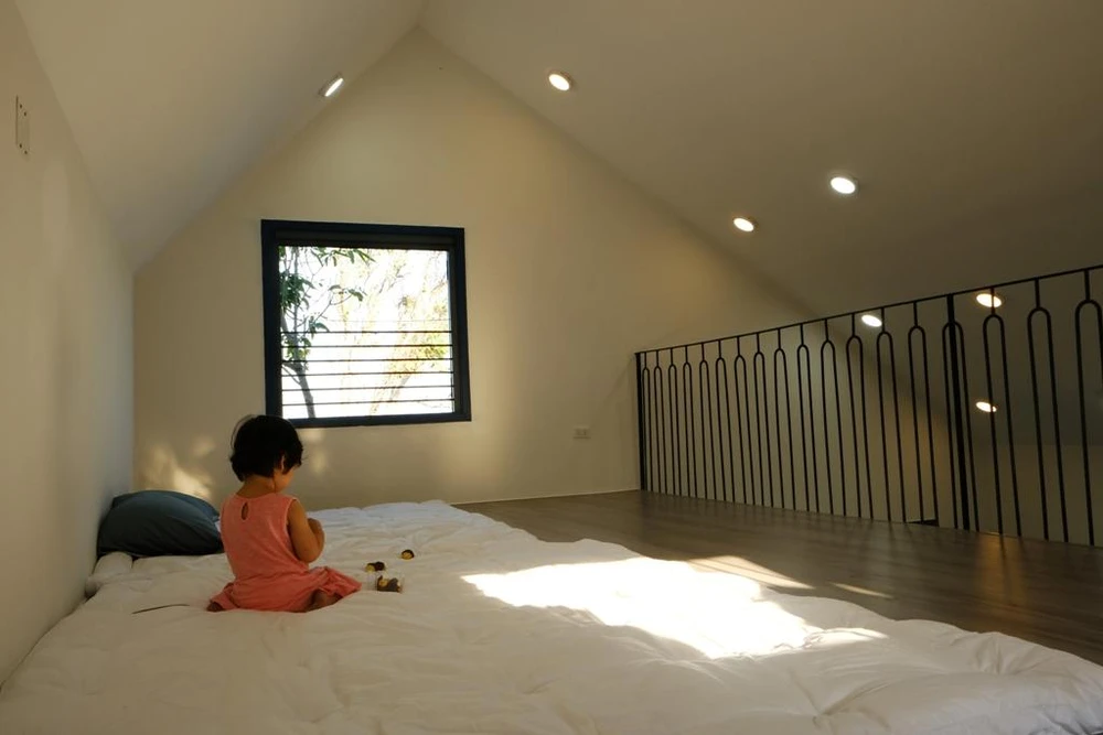 Khu vực gác xép được thiết kế tối giản với ô cửa sổ thông gió mở trực tiếp hướng nhìn ra biển, là nơi ngủ của các con khi về thăm, hoặc khách đến chơi ở lại.