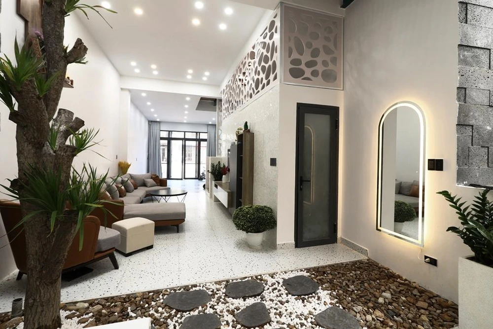 Kết nối giữa phòng khách và bếp là khoảng sân vườn nhỏ giữa nhà.