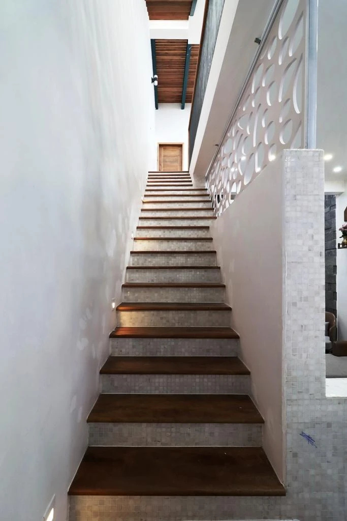 Cầu thang dẫn lên các tầng trên thiết kế đơn giản với gam màu tối.