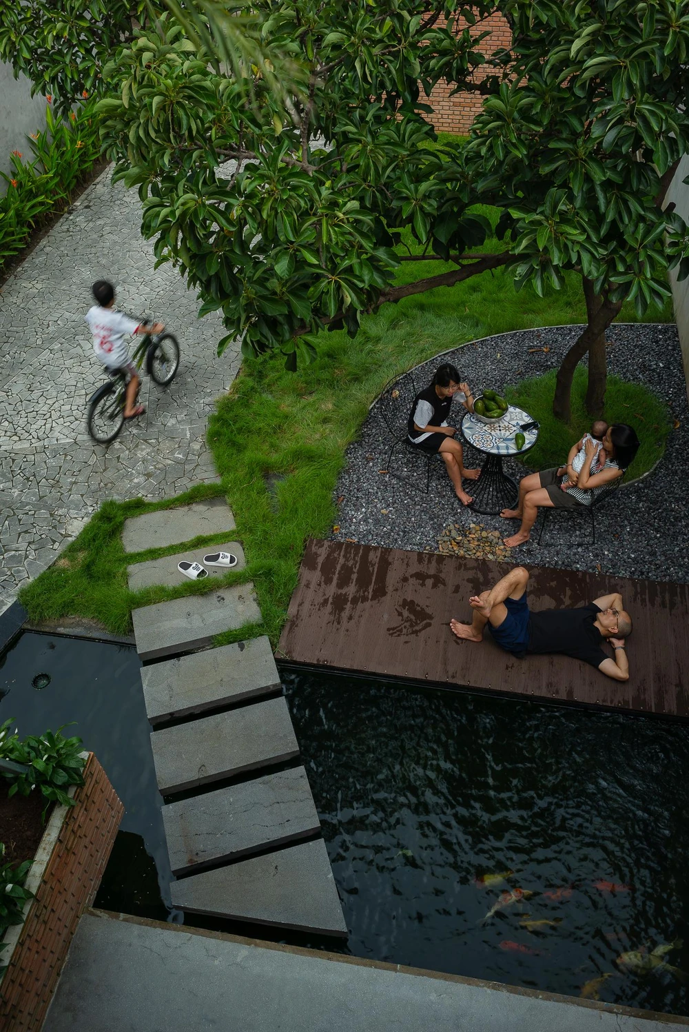 Bể nước nuôi cá và chiếc bàn nhỏ xinh dưới tán cây lớn là nơi thư giãn, vui chơi của gia đình.