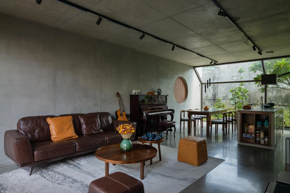 Chiếc ghế sofa, bàn tròn trên tấm thảm rộng làm nổi bật không gian phòng khách.