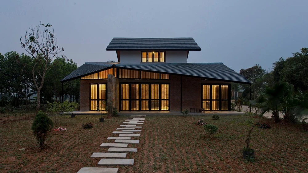 Folded Roof House có diện tích 120 m², bao bọc bởi cây xanh của sân vườn.