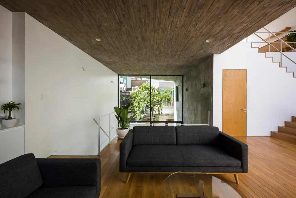 Phòng khách được bố trí ở tầng hai, nằm trên đường giao thông trục dọc của ngôi nhà.