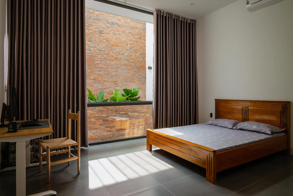 Phòng ngủ tầng trên đón nắng thông qua ban công khu vực giếng trời.