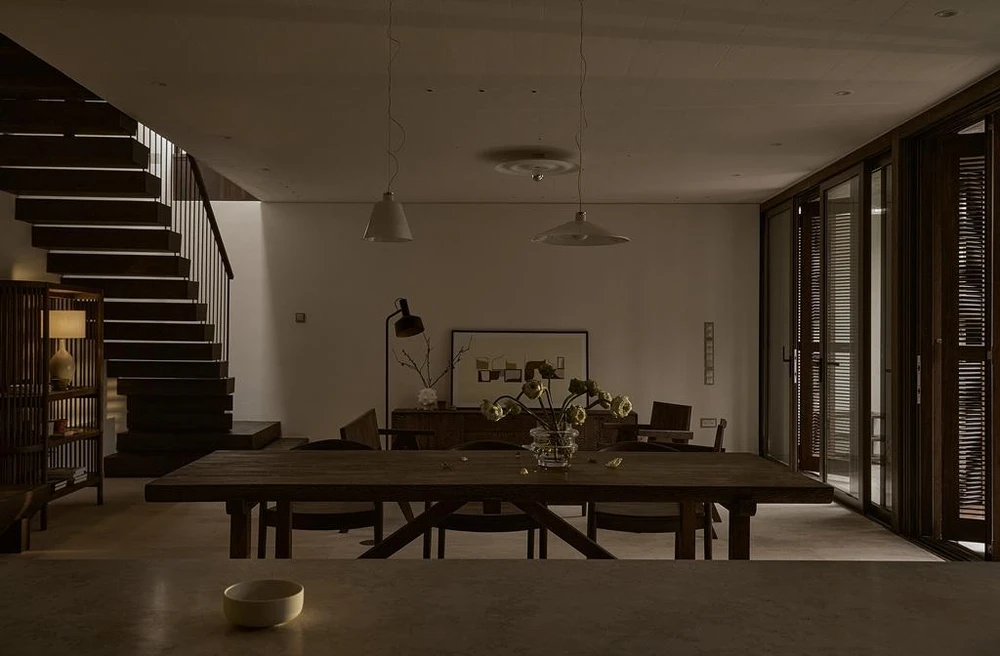 Ngôi nhà chạy dài nằm dưới tán cây gần gũi và thân quen, nó giống như khung cảnh của những ngôi nhà truyền thống Việt Nam.