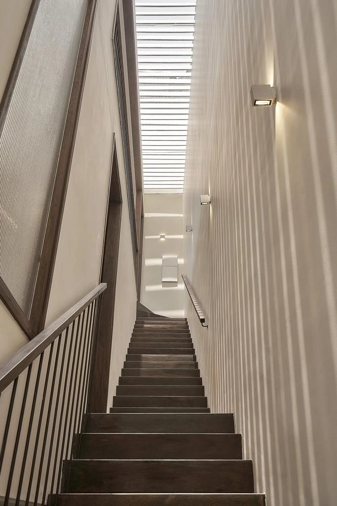 Cầu thang dẫn lên tầng lầu lấy sáng từ việc thiết kế giếng trời.