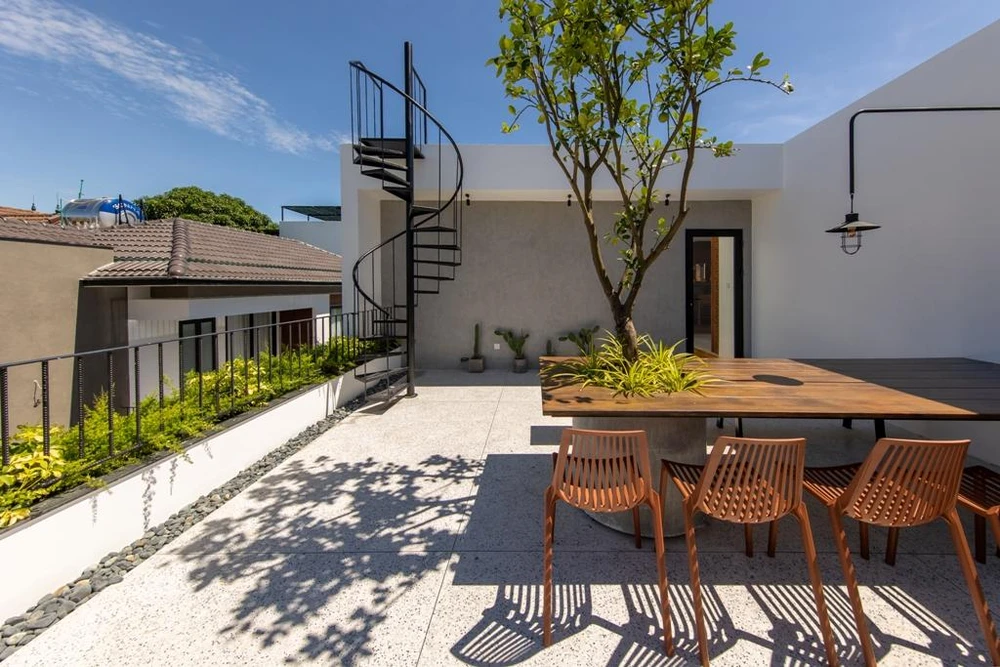 Kiến trúc sư còn thiết kế thêm bộ bàn ăn xoay quanh gốc cây lớn, đây là nơi thư giãn của gia đình mỗi khi trời mát.