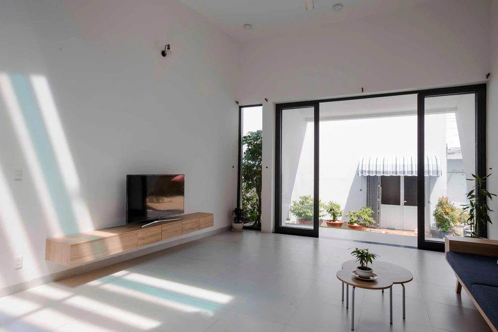 Bước vào bên trong căn nhà là một không gian thoáng đãng nhờ cách bố trí khéo léo để hứng trọn ánh sáng tự nhiên chiếu rọi và khoảng xanh với cây cối quanh nhà.