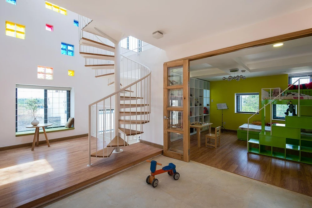 Góc sinh hoạt gia đình được tô điểm thêm bởi cầu thang xoắn với thiết kế nhẹ nhàng, trang nhã.