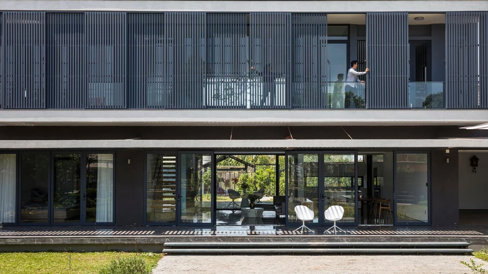 Hàng hiên dài không cột trở thành vùng đệm che nắng giảm nhiệt, tạo khu vực chuyển tiếp giữa không gian bên trong và bên ngoài.