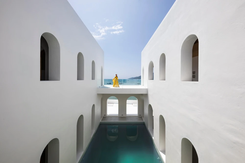 Bể bơi mang lại màu xanh nổi bật giữa những bức tường trắng.