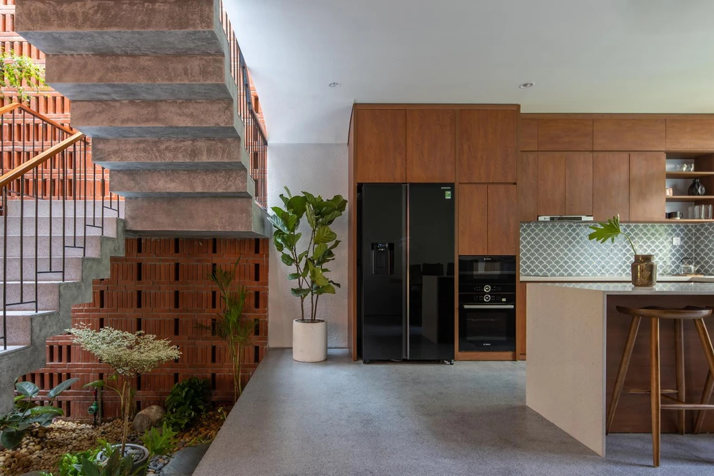 Phòng khách và bếp liên thông với nhau bằng giếng trời và khu vườn nhỏ ở giữa. Phòng khách và bếp liên thông với nhau bằng giếng trời và khu vườn nhỏ ở giữa.