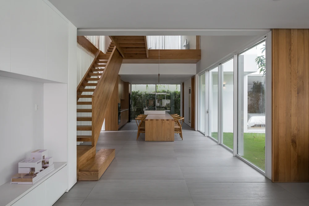 Phòng ăn với khoảng giếng trời và hành lang gỗ nối phía trên giúp tăng cường sự tương tác.