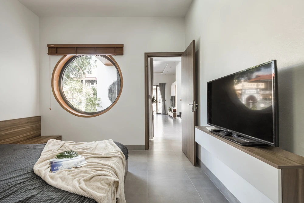 Phòng ngủ đón ánh sáng tự nhiên từ các ô cửa tròn.