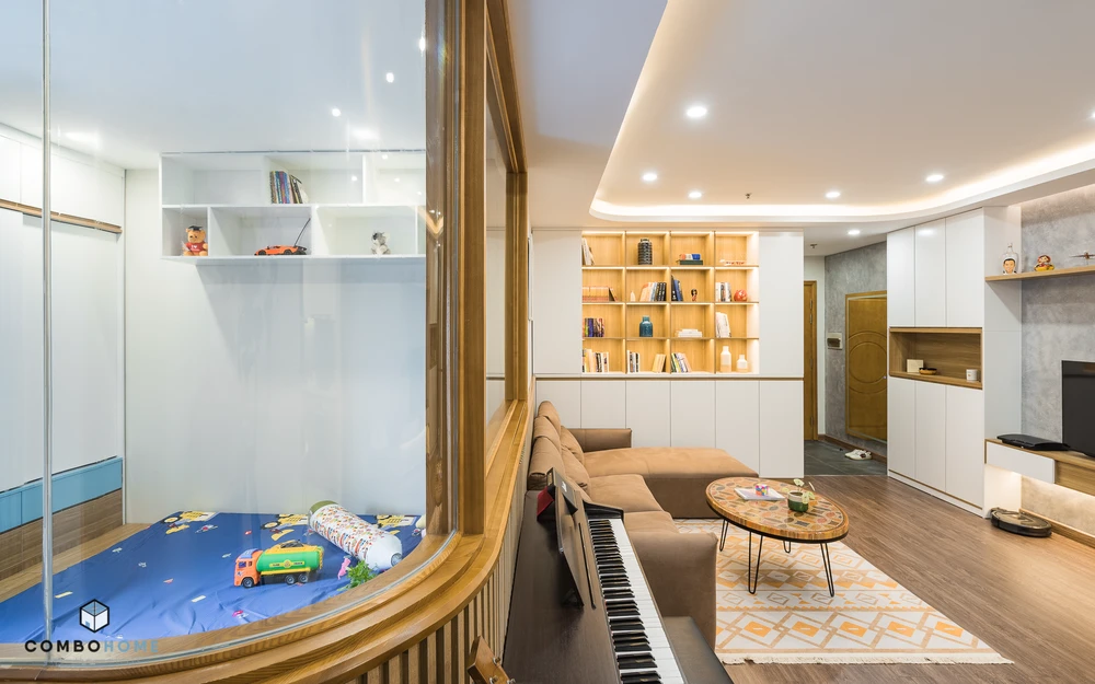 Phương án sử dụng kính cong trong không gian kết nối các khu vực và lấy được ánh sáng từ ban công vào phòng khách, đồng thời tạo nên góc mềm mại hơn cho căn hộ.