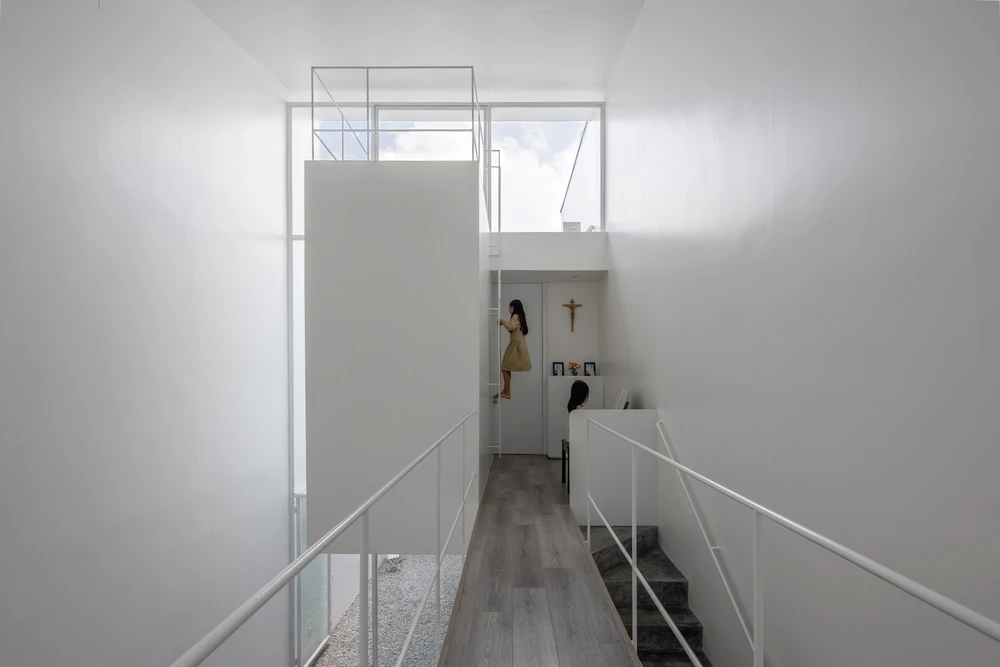 Bức tường kính lớn của giếng trời ở phía nam nhà mang đến tầm nhìn bao quát ra khu vườn sau nhà.