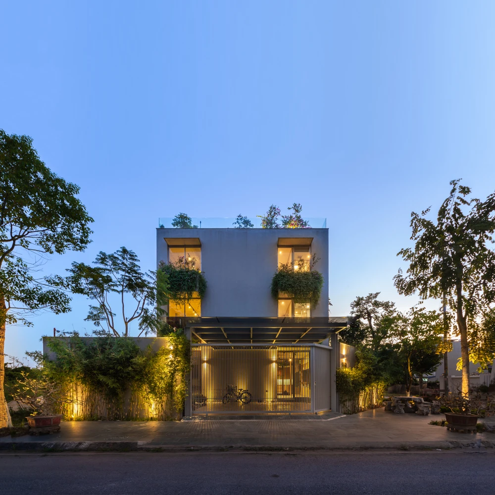 Màu gạch sơn nước xi măng bền với thời gian, tương phản với vật liệu nhôm kính hiện đại bên trong.