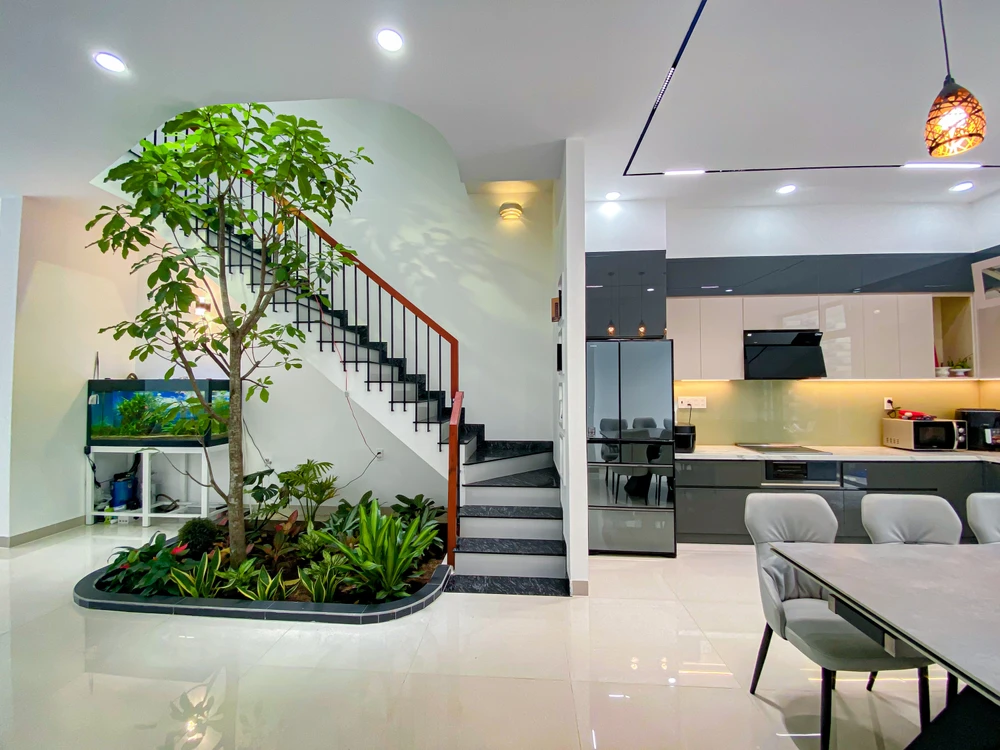 Tại khu vực chân cầu thang, kiến trúc sư thiết kế khu tiểu cảnh với nhiều cây xanh mang đến sức sống cho ngôi nhà ở thành thị.