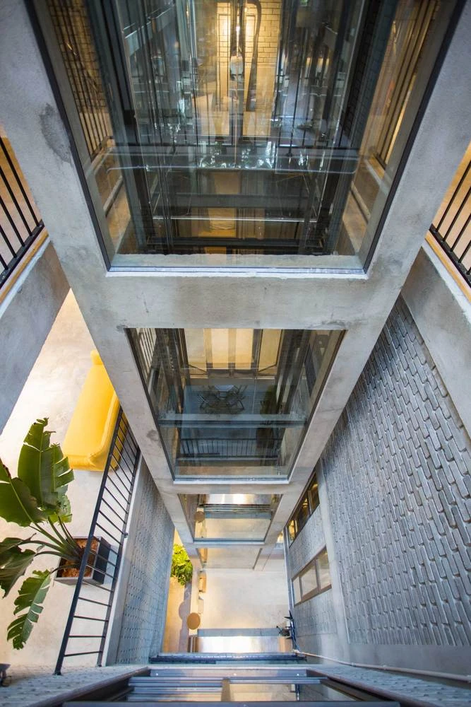 Mặt sau của tòa nhà là văn phòng và sân vườn. Thang máy được thiết kế bằng kính mang đến cảm giác rộng rãi, thoáng mát.