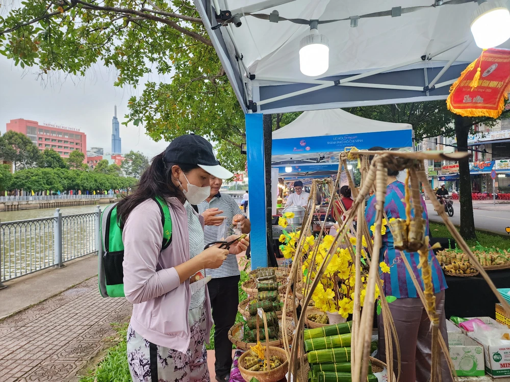 Du khách tham quan và thưởng thức gian hàng các loại bánh tét.