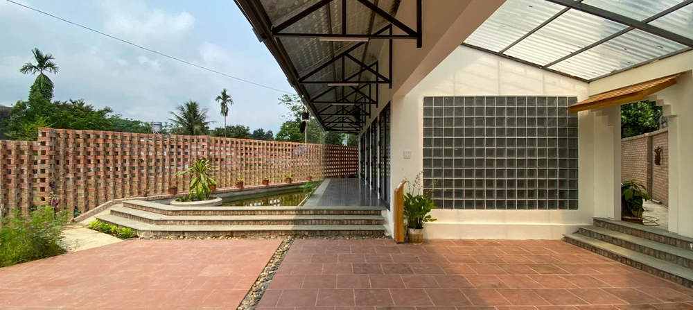 Sân vườn làm từ các vật liệu gần gũi và giản dị: sân lát gạch đất nung (gạch đỏ) thay vì gạch men hay đổ bê tông do gạch đất nung sẽ hút ẩm, hút nước nên sẽ làm mát sân.