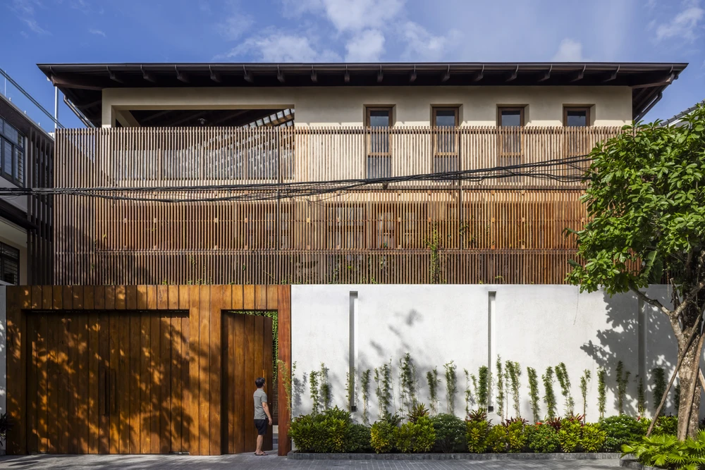 Mặt tiền của công trình được bố trí hệ lam gỗ linh hoạt đóng - mở dựa theo nhu cầu sử dụng, đem lại ấn tượng khi nhìn từ bên ngoài.