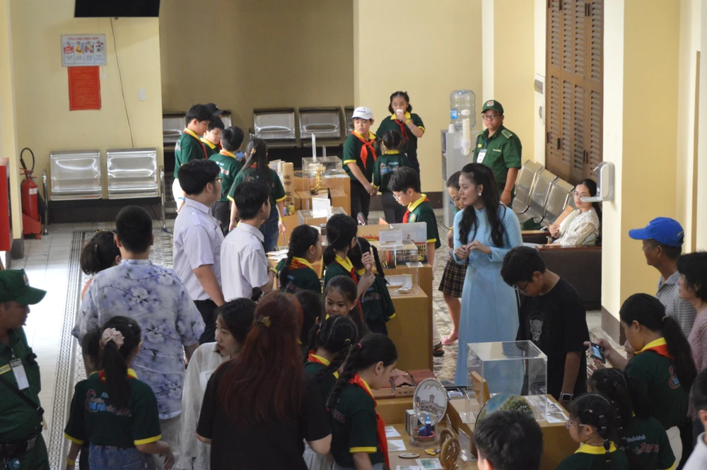 Khách tham quan và mua sắm quà lưu niệm trong chương trình tour tham quan di tích kiến trúc nghệ thuật cấp quốc gia trụ sở HĐND và UBND TP.HCM. Ảnh: THU TRINH.