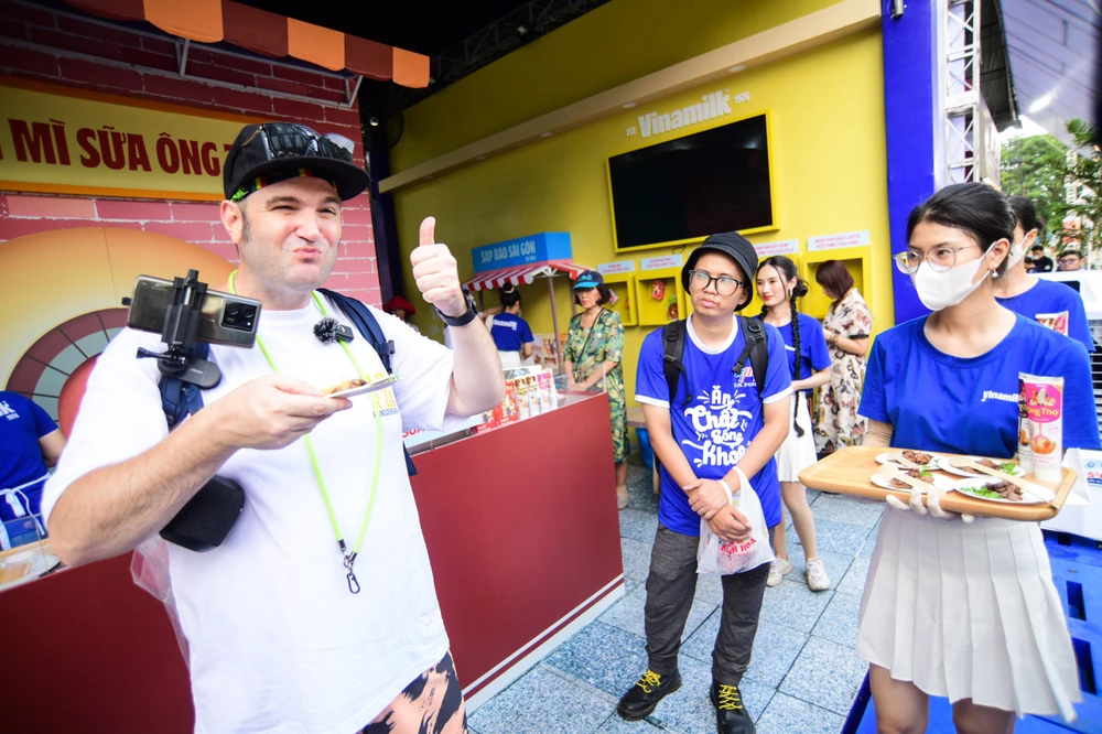 Du khách quốc tế thưởng thức bánh mì chấm sữa tại lễ hội bánh mì Việt Nam tại TP.HCM. Ảnh: TT.