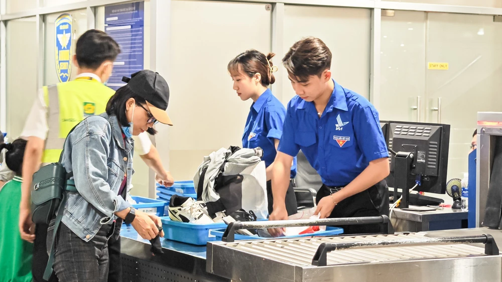 Đoàn viên Đoàn thanh niên cảng hỗ trợ hành khách tại khu vực khu vực an ninh soi chiếu, khu vực sảnh công cộng nhà ga quốc nội dịp hè. Ảnh: TT.