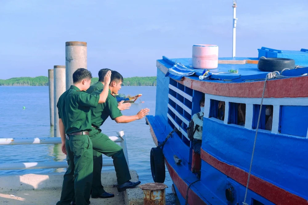 Cán bộ, chiến sĩ Đồn biên phòng Thạnh An chào tạm biệt các em vào đất liền dự thi tốt nghiệp THPT. Ảnh:TT.