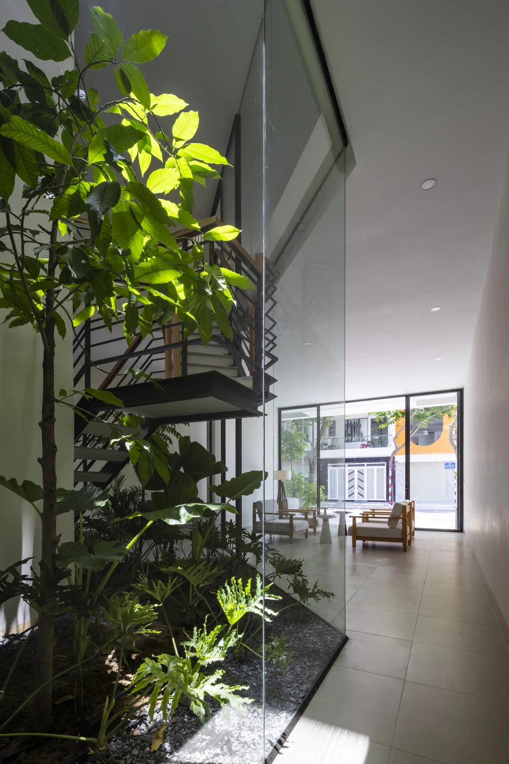 Kiến trúc sư Pham Huu Son Architects cho biết, cây xanh được sắp đặt xuyên suốt từ ngoài vào trong, từ tầng trệt lên đến sân thượng, tạo nên một hệ sinh thái vi khí hậu riêng, giúp ngôi nhà phố hiện đại luôn thoáng mát và gần gũi thiên nhiên.
