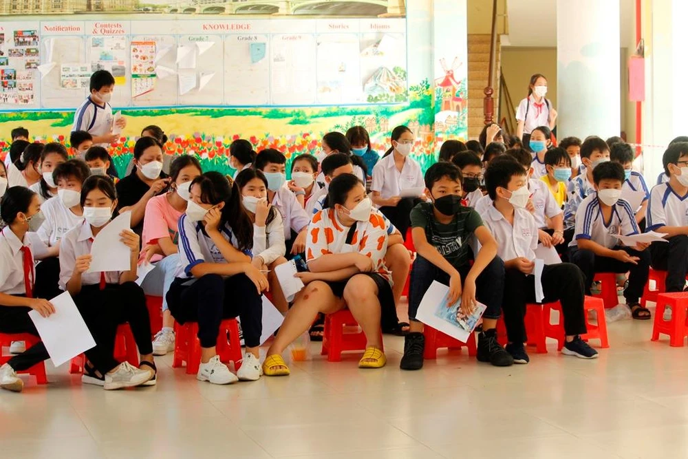 Rất đông học sinh lớp 6 Trường THCS Đoàn Thị Điểm đã có mặt tại trường để chờ vào tư vấn tiêm phòng COVID-19. Ảnh: NHẪN NAM