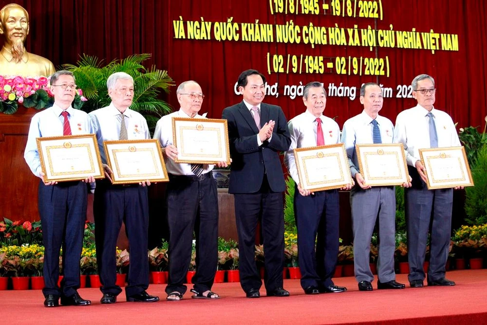 Bí thư Thành ủy Lê Quang Mạnh trao huy hiệu đảng cho sáu đảng viên cao tuổi. Ảnh: NHẪN NAM