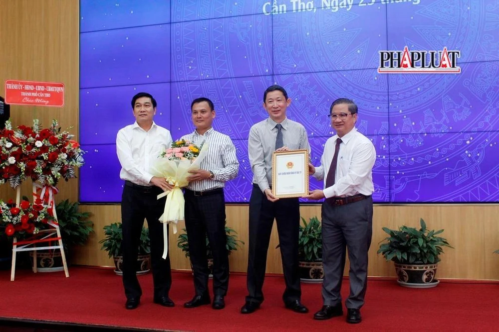 Đại diện các nhà đầu tư nhận giấy chứng nhận đầu tư và hoa chúc mừng tại buổi lễ chiều 25-10. Ảnh: NHẪN NAM