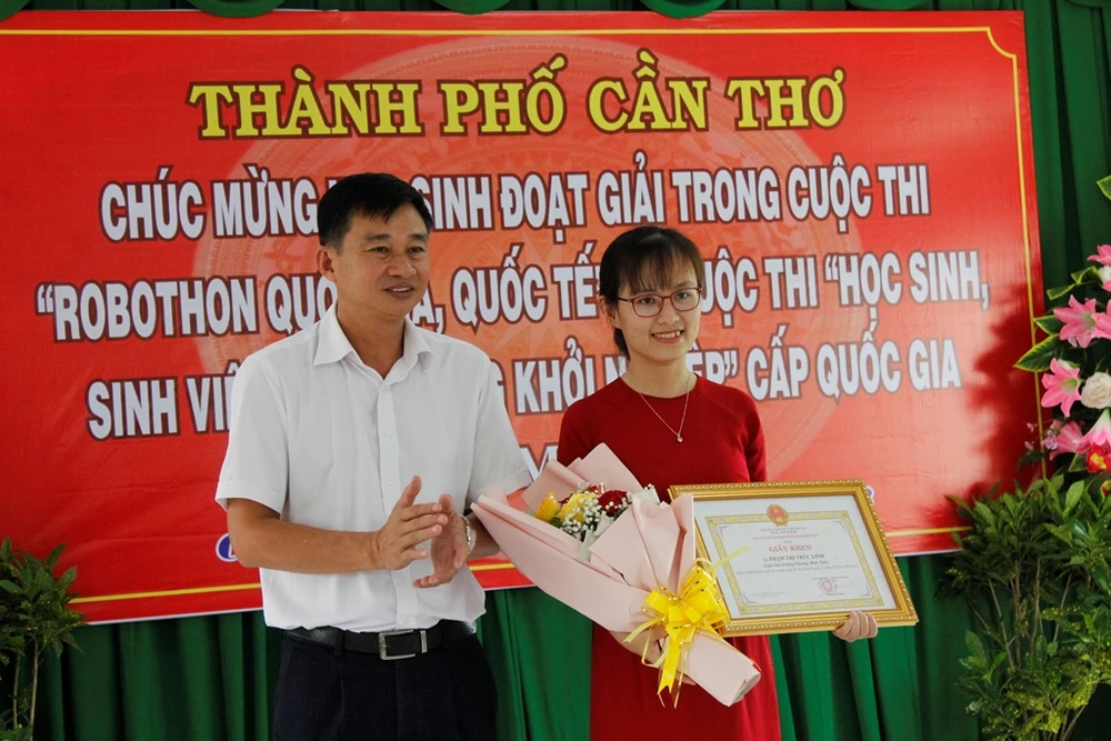 Lãnh đạo UBND quận Bình Thủy tặng bằng khen cho cô giáo Phạm Thị Trúc Linh do có thành tích xuất sắc tại cuộc thi Robothon quốc tế năm 2023 tại Malaysia. Ảnh: NHẪN NAM