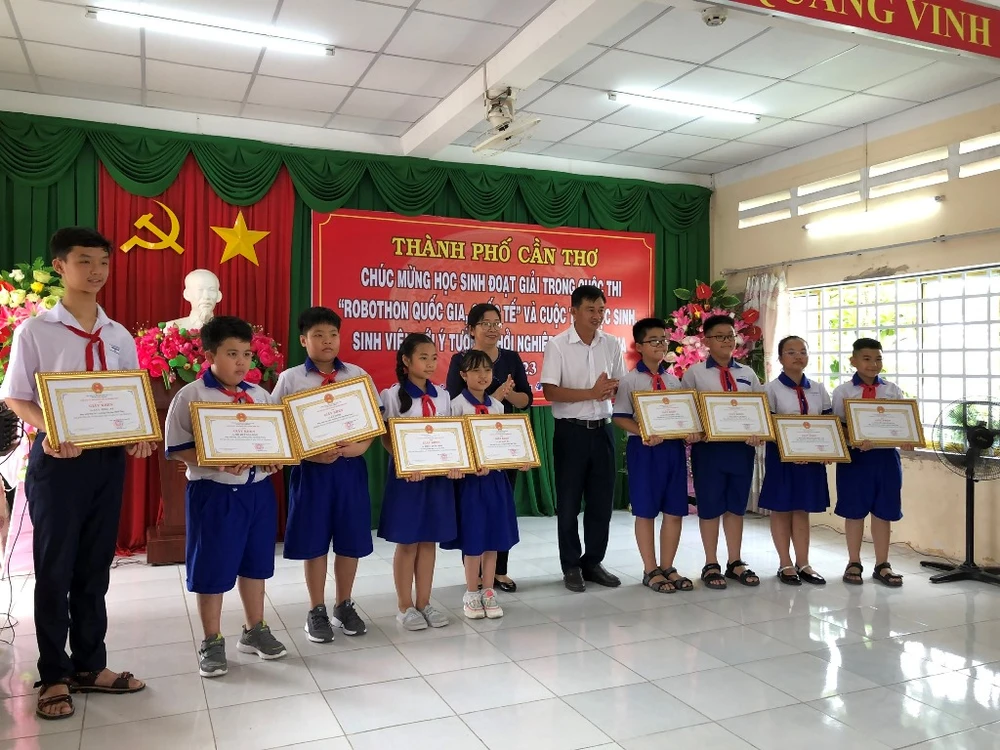 Phó Chủ tịch UBND quận, Trưởng phòng GD&amp;ĐT quận Bình Thủy tặng bằng khen cho các học sinh của quận. Ảnh: NHẪN NAM