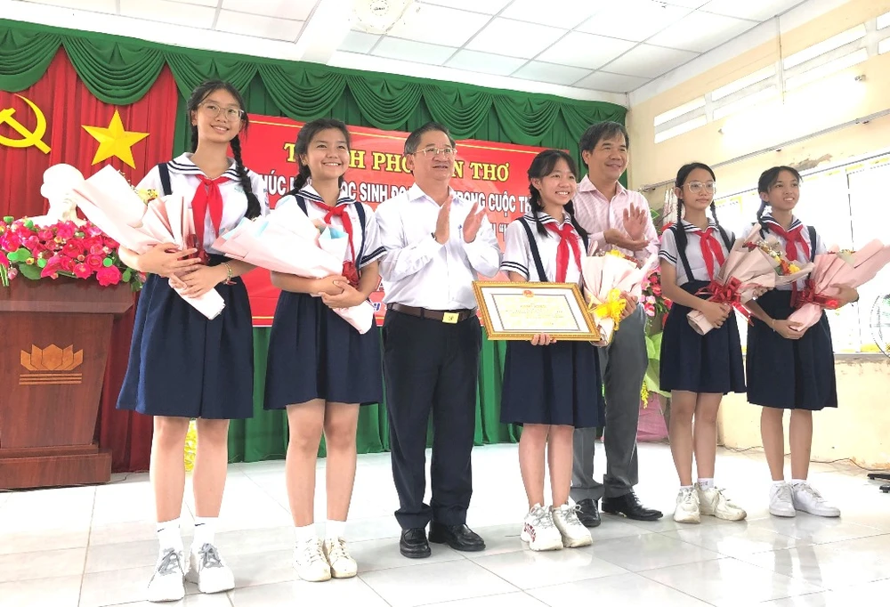 Chủ tịch UBND TP Cần Thơ, Phó Giám đốc Sở GD&amp;ĐT tặng bằng khen, hoa chúc mừng nhóm học sinh Trường THCS Thới Long. Ảnh: NHẪN NAM