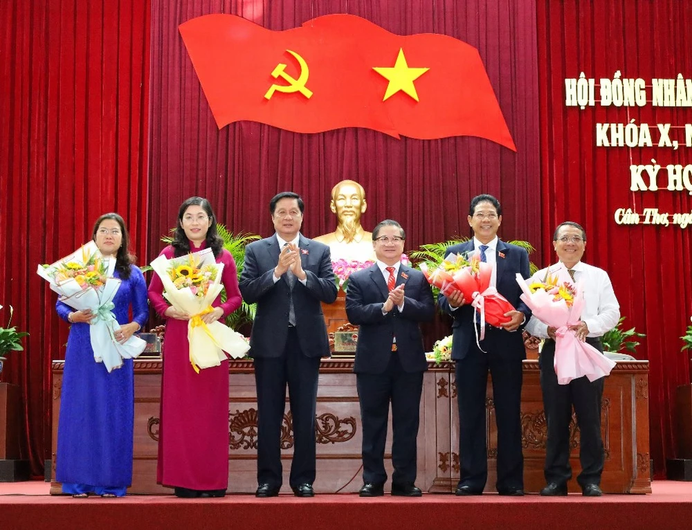 Chủ tịch HĐND, UBND TP Cần Thơ tặng hoa các ông, bà vừa được miễn nhiệm, bầu bổ sung Ủy viên UBND TP. Thượng tá Huỳnh Văn Hung vắng mặt do đang đi công tác. Ảnh: CTV