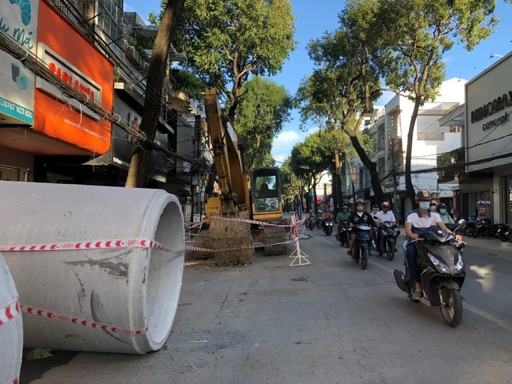 Đơn vị thi công đang thực hiện đặt cống tại tuyến đường Nguyễn Trãi. Ảnh chụp chiều 11-8. Ảnh: NHẪN NAM