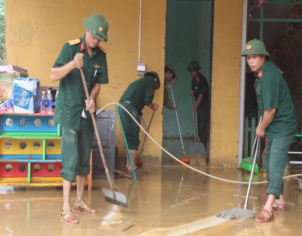 dọn dẹp bùn đất sau lũ.