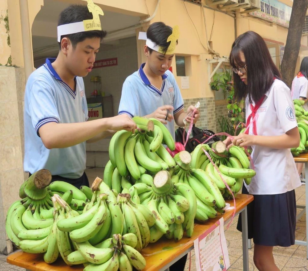 Các bạn nhỏ tìm cách sắp xếp chuối sao cho bắt mắt khách hàng. Ảnh: P.ANH