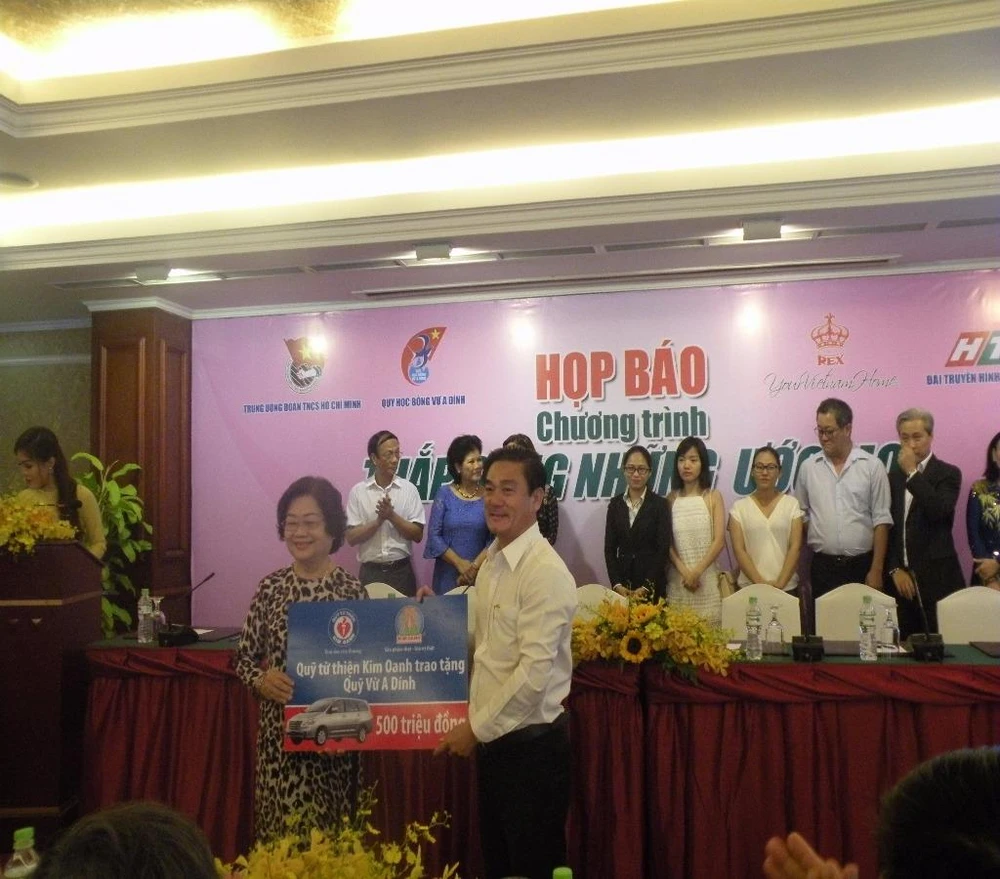 Bà Trương Mỹ Hoa, đại diện Qũy nhận quà tặng tượng trưng từ Qũy từ thiện Kim Oanh.