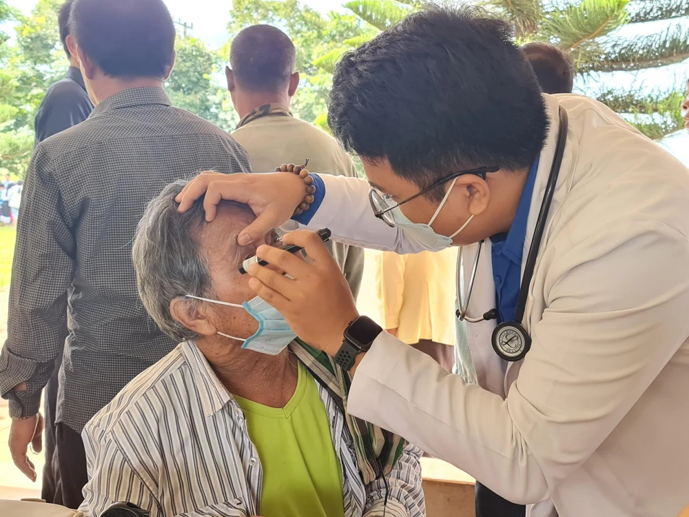 Bác sĩ đang khám bệnh cho bà con Lào. Ảnh: TRẦN NGỌC