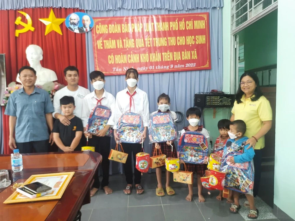 Học sinh xã Tân Ninh nhận lồng đèn và bánh trung thu. Ảnh: LƯU NGÂN