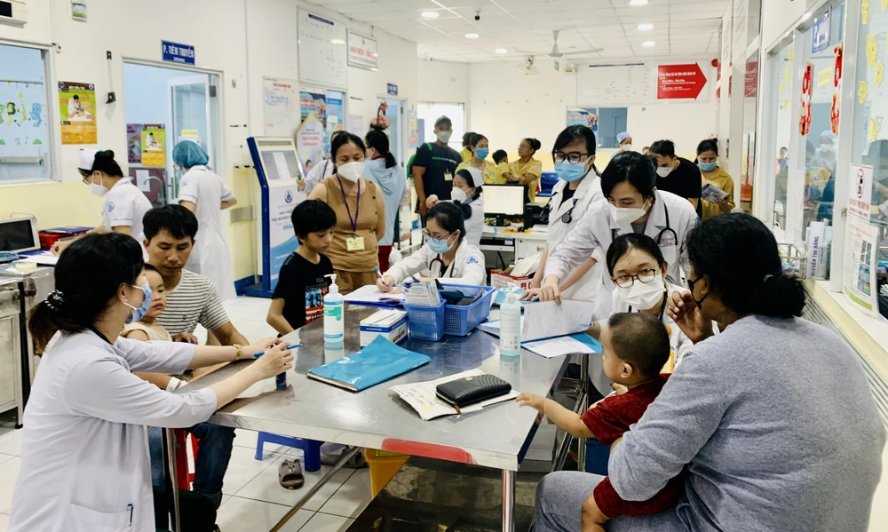 Phụ huynh đưa trẻ đến khám tay chân miệng tại khoa Nhiễm - thần kinh, BV Nhi đồng 1. Ảnh: THẢO PHƯƠNG