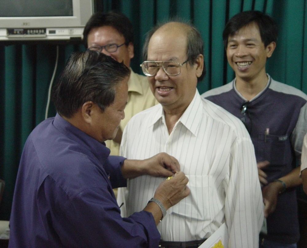 Nhà báo Nam Đồng - Tổng Biên tập báo Pháp Luật TP.HCM trước đây - trao kỷ niệm chương Vì sự nghiệp 20 năm làm báo cho LS Phan Đăng Thanh. Ảnh: HTD