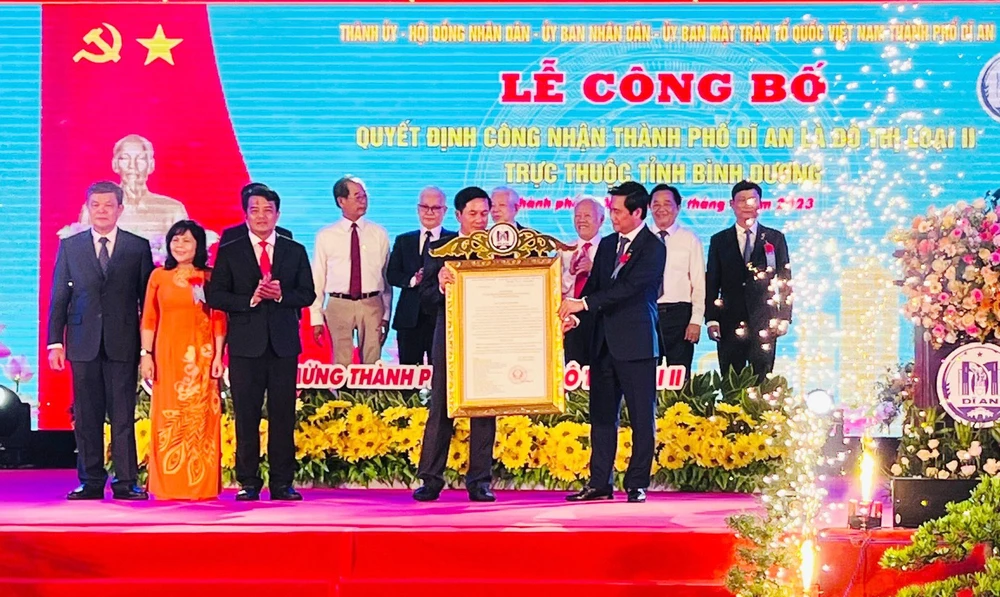 Ông Nguyễn Tường Văn- Thứ trưởng Bộ Xây dựng (phải), thừa ủy quyền của Thủ Tướng Chính phủ lên Trao Quyết định của Thủ tướng Chính phủ công nhận TP Dĩ An là Đô Thị loại II trực thuộc tỉnh