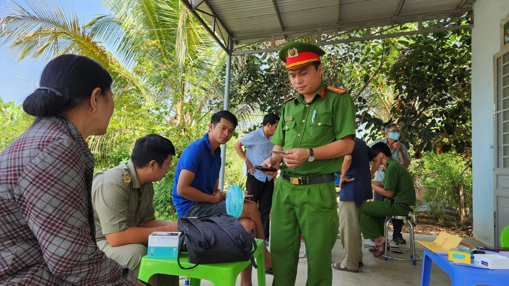 Thiếu tá Hoàng Trung Kiên cùng công an thị trấn Madaguôi phấn đấu hoàn thành sớm việc cấp căn cước công dân trên địa bàn