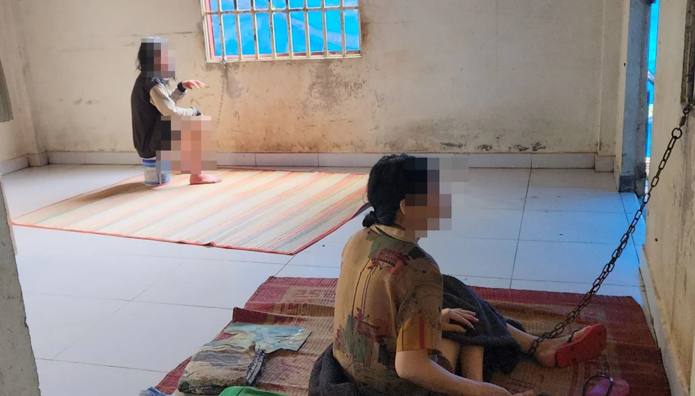 Hai người phụ nữ bị xích chân vào cửa sổ. Ảnh: VÕ TÙNG