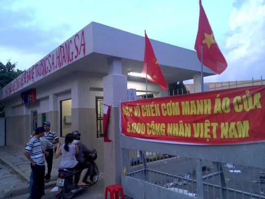 Chiều 14-5, công nhân Công ty Esquel ở Bình Dương treo khẩu hiệu phản đối việc đập phá của các đối tượng quá khích - Ảnh: Như Phú